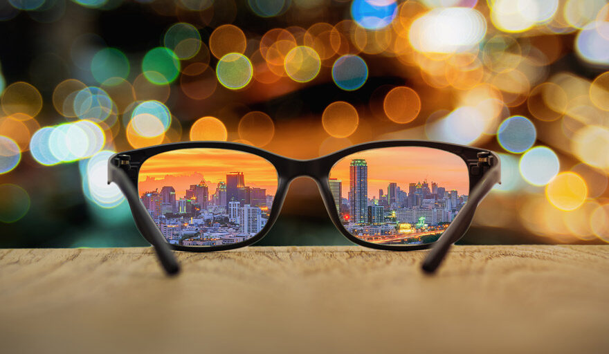 A pair of glasses with the city shining through