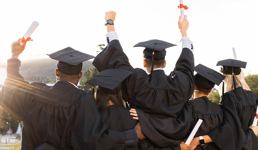 Group of excited graduates, facing away from camera