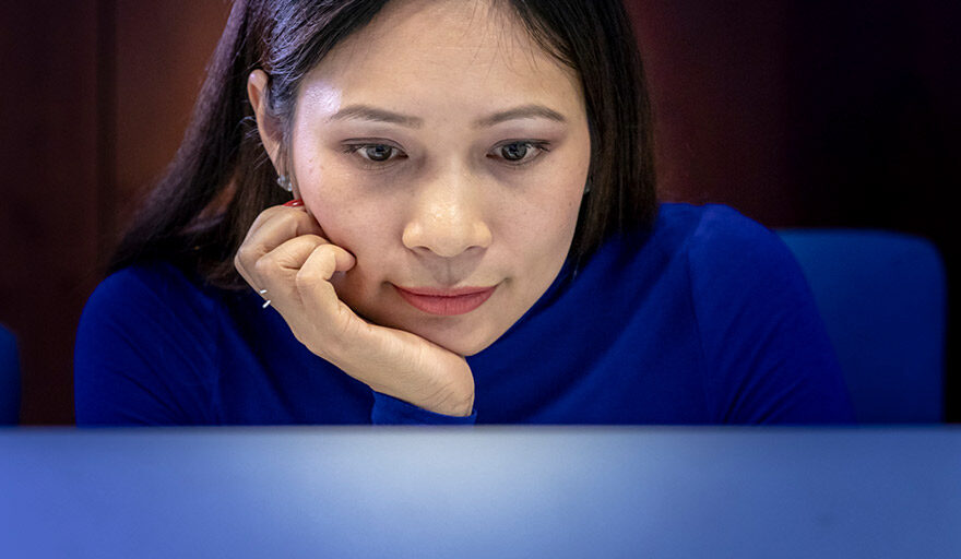 Woman starting thoughtfully at her computer.