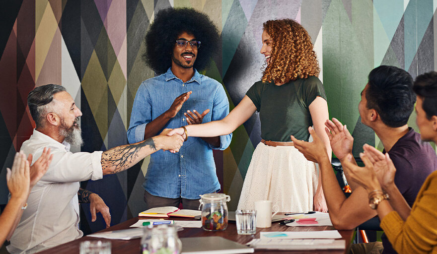 Group of people gathered around a table clapping