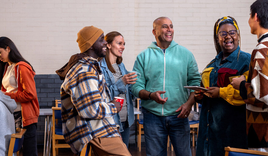 Group of diverse people having a conversation while holding coffee cups