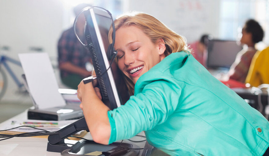Woman smiling and hugging her computer monitor