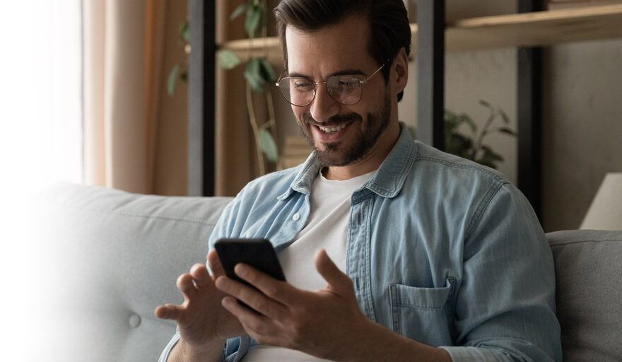 Happy man looking at his cell phone