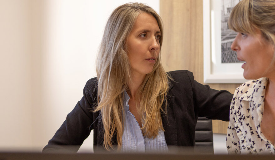 Two women looking concerned and having a serious conversation at work.